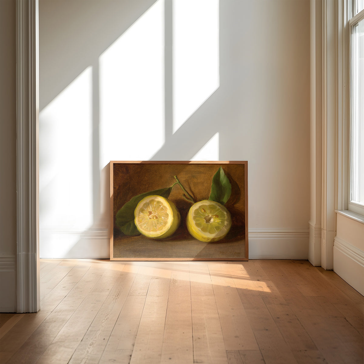 Framed artwork of two lemons on a wooden floor with sunlight streaming through a window.
