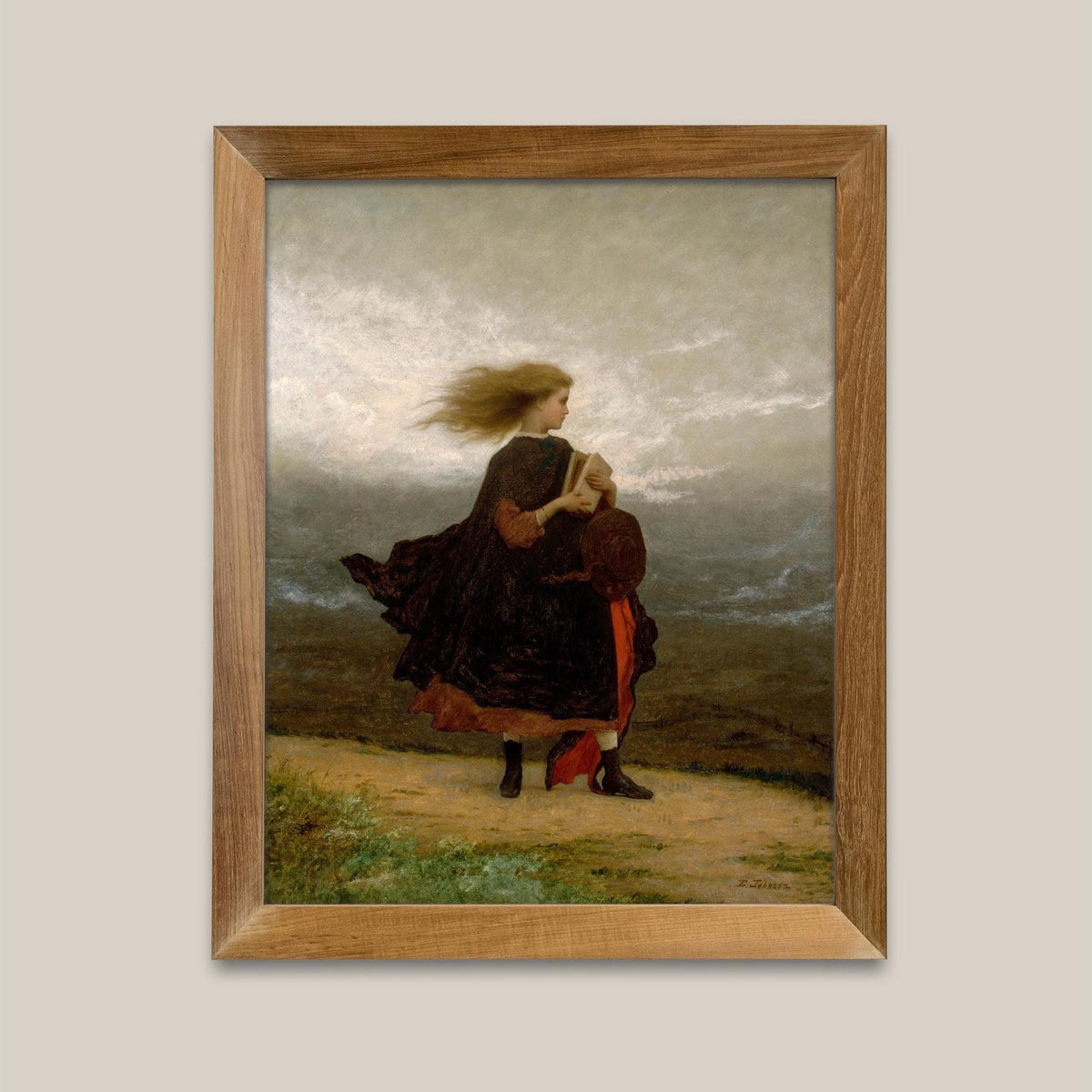 A fine art print hangs on a neutral coloured wall in a wooden picture frame. The picture depicts a windswept young lady walking across a landscape in a velvet coat and holding a book.