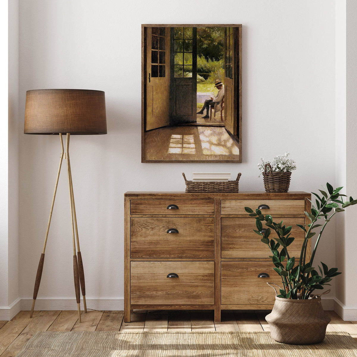 Wooden dresser with a mirror, lamp, and plant in a room setting with a framed portrait of a man in an open doorway