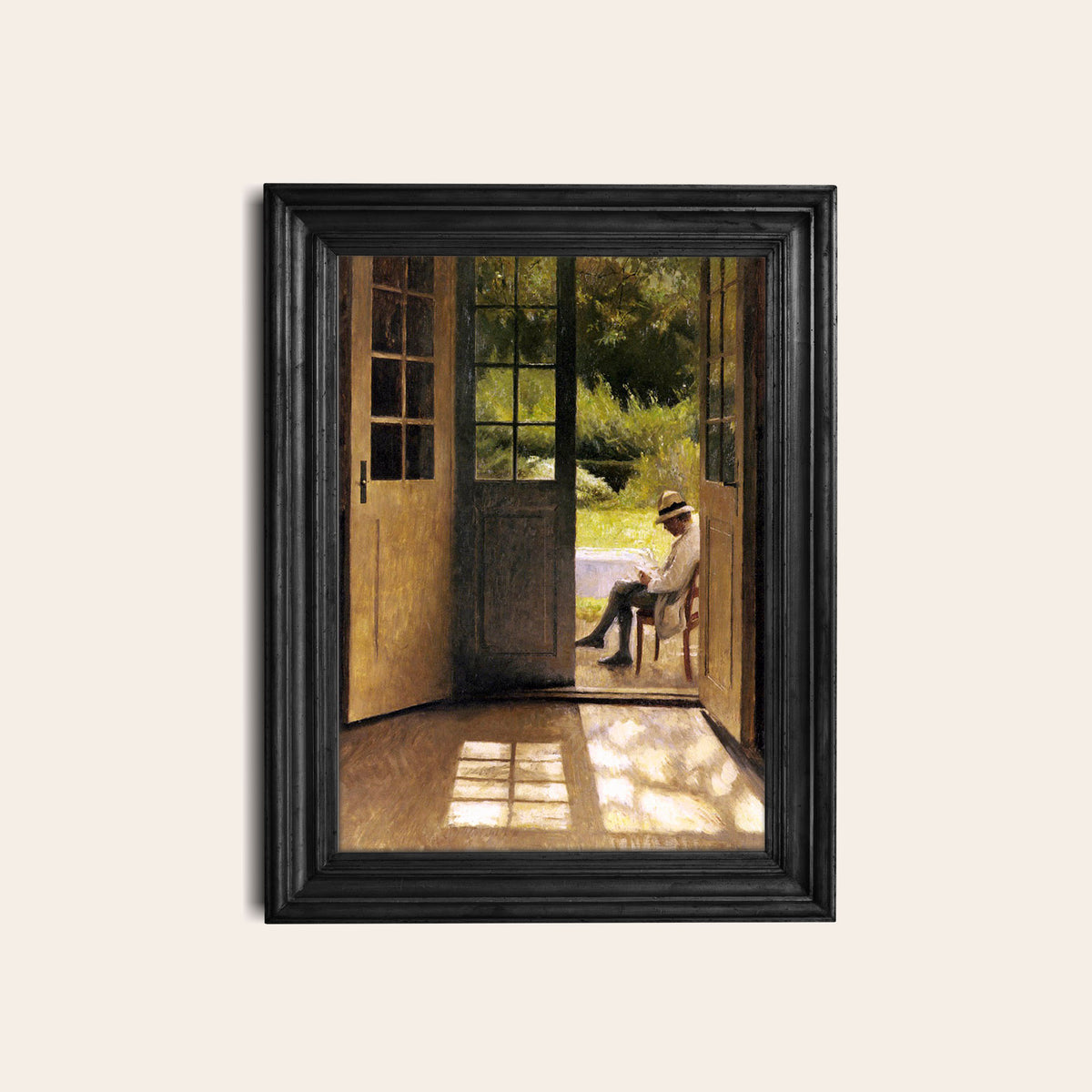 Framed artwork of a man sitting on a chair in a garden in a black frame hung on a light wall