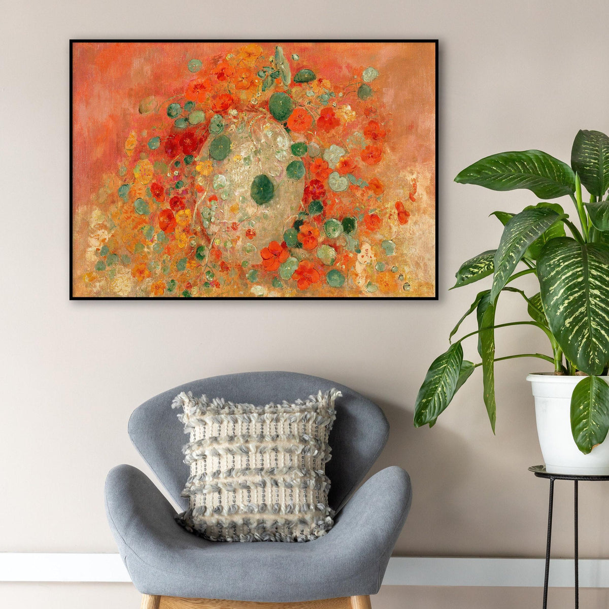 A fine art print of Odilon Redon's oil painting, Nasturtiums, from 1905. The print is displayed in a thin black picture frame, hung in a living room above a grey chair, beside a plant.