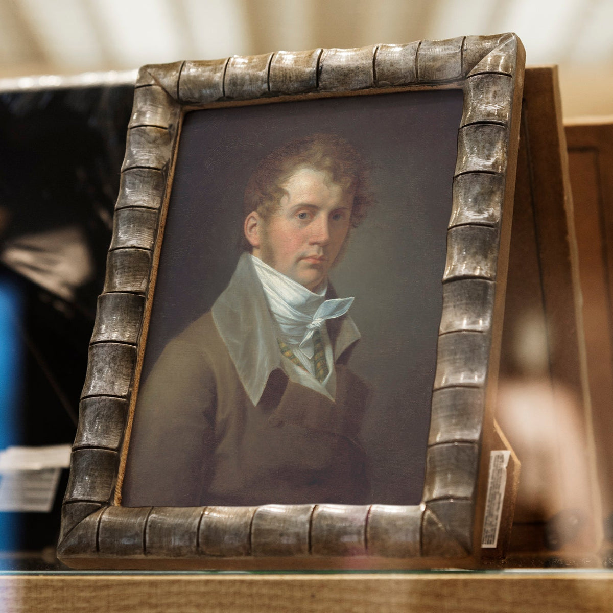 Small portrait of a man in a decorative frame on a table