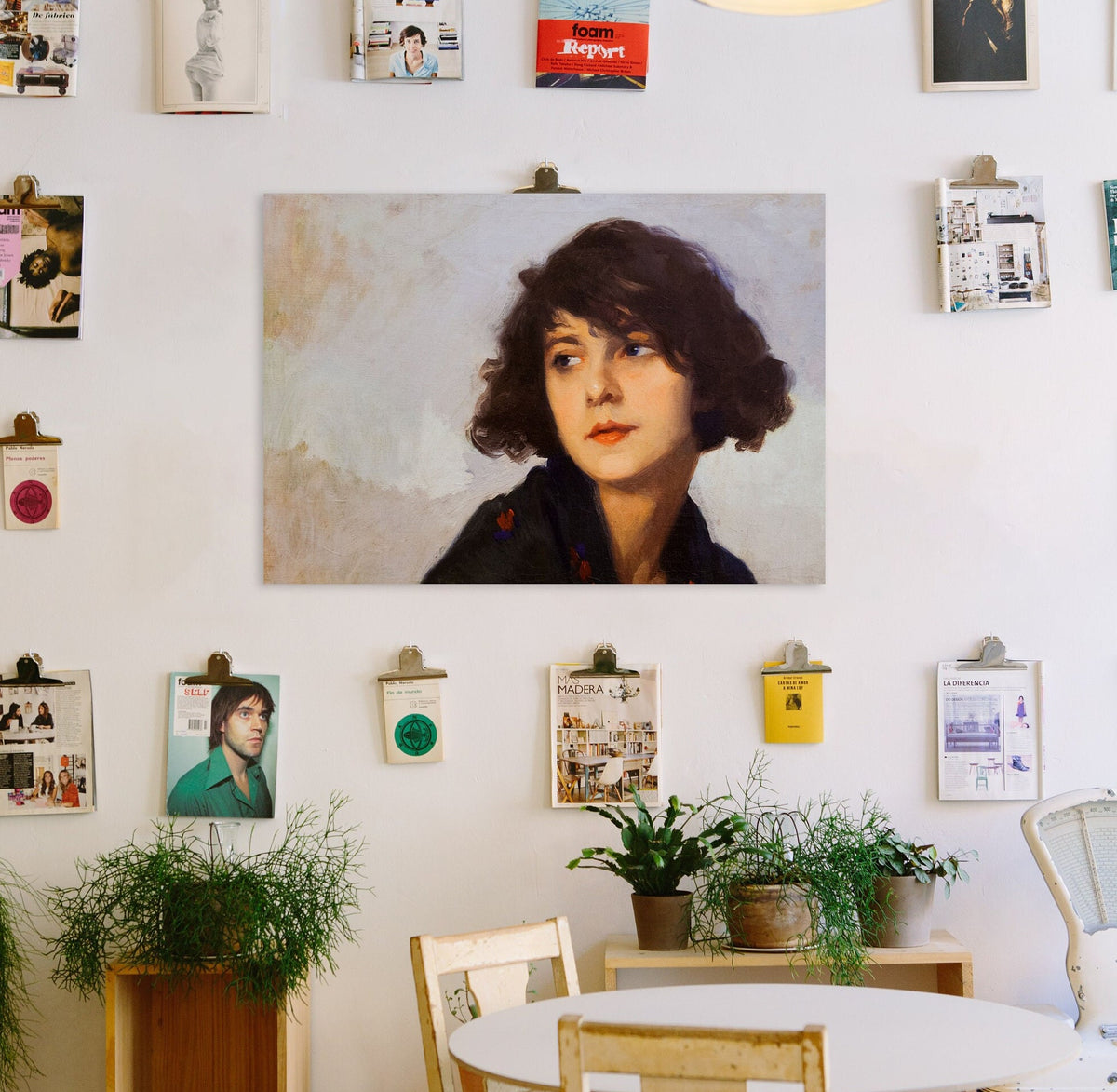 A fine art print of a portrait in oil of a young lady from the Art Deco period. The print is displayed hanging on the wall with other things of interest.