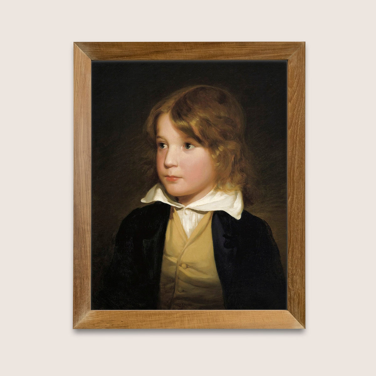 Framed portrait of a young boy on a dark background, in a wooden frame hung on a light background