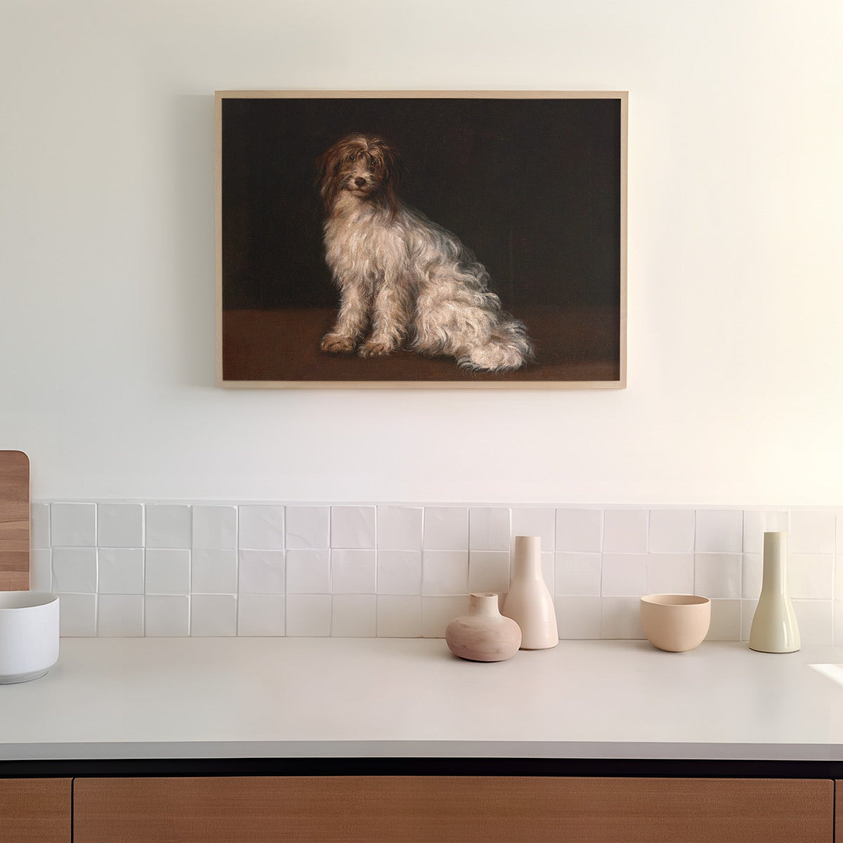 Framed artwork of a dog on a dark background hanging in a kitchen above a counter top.