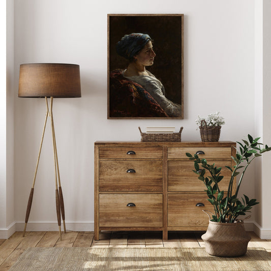 Wooden dresser with a lamp, plant, and framed portrait in a modern living room.