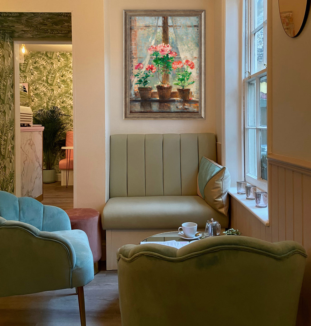Cozy living room with a green sofa, green armchair, and a fine art print of flowers on the wall.