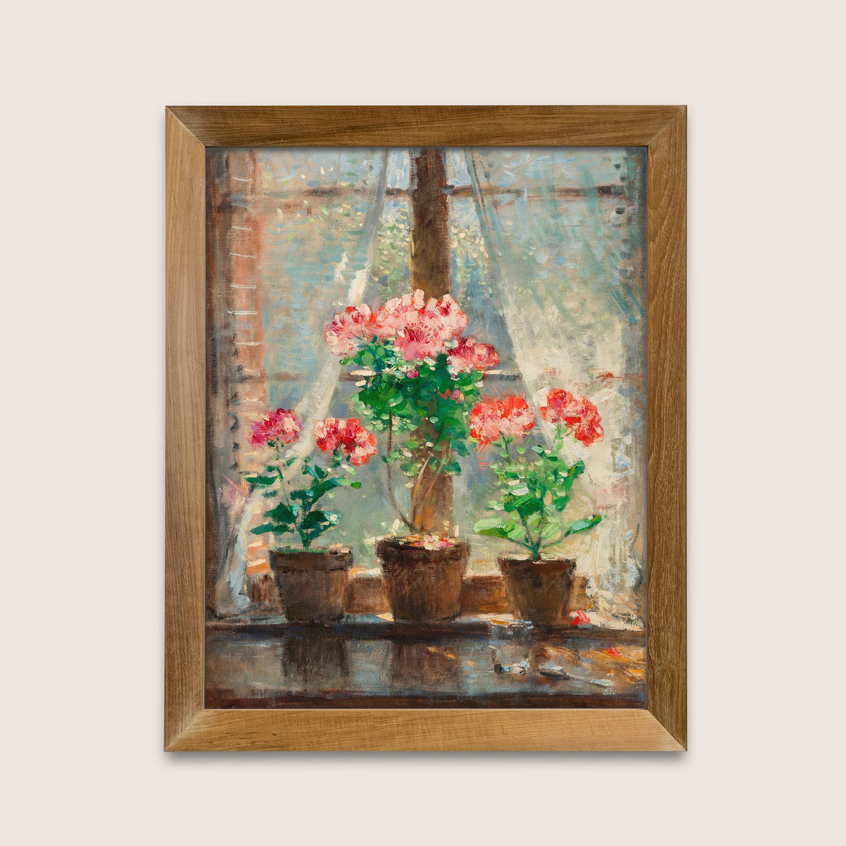 Framed print of potted flowers in front of a window, hung in a wooden picture frame on a white wall.