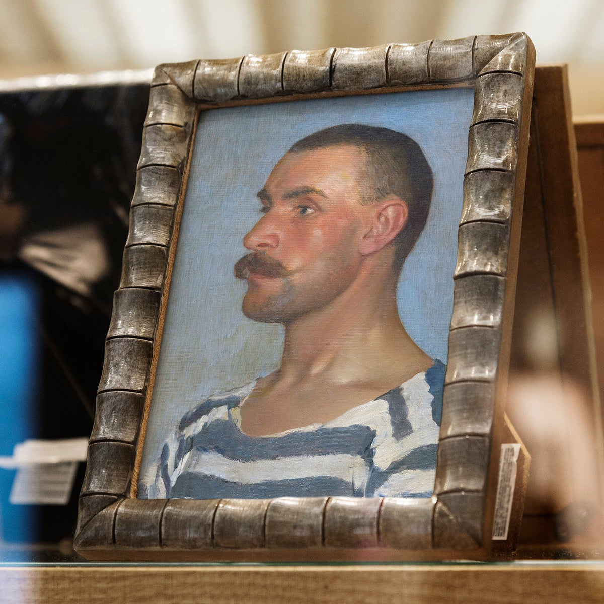 Portrait of a man with a mustache in a decorative frame on a blurred background