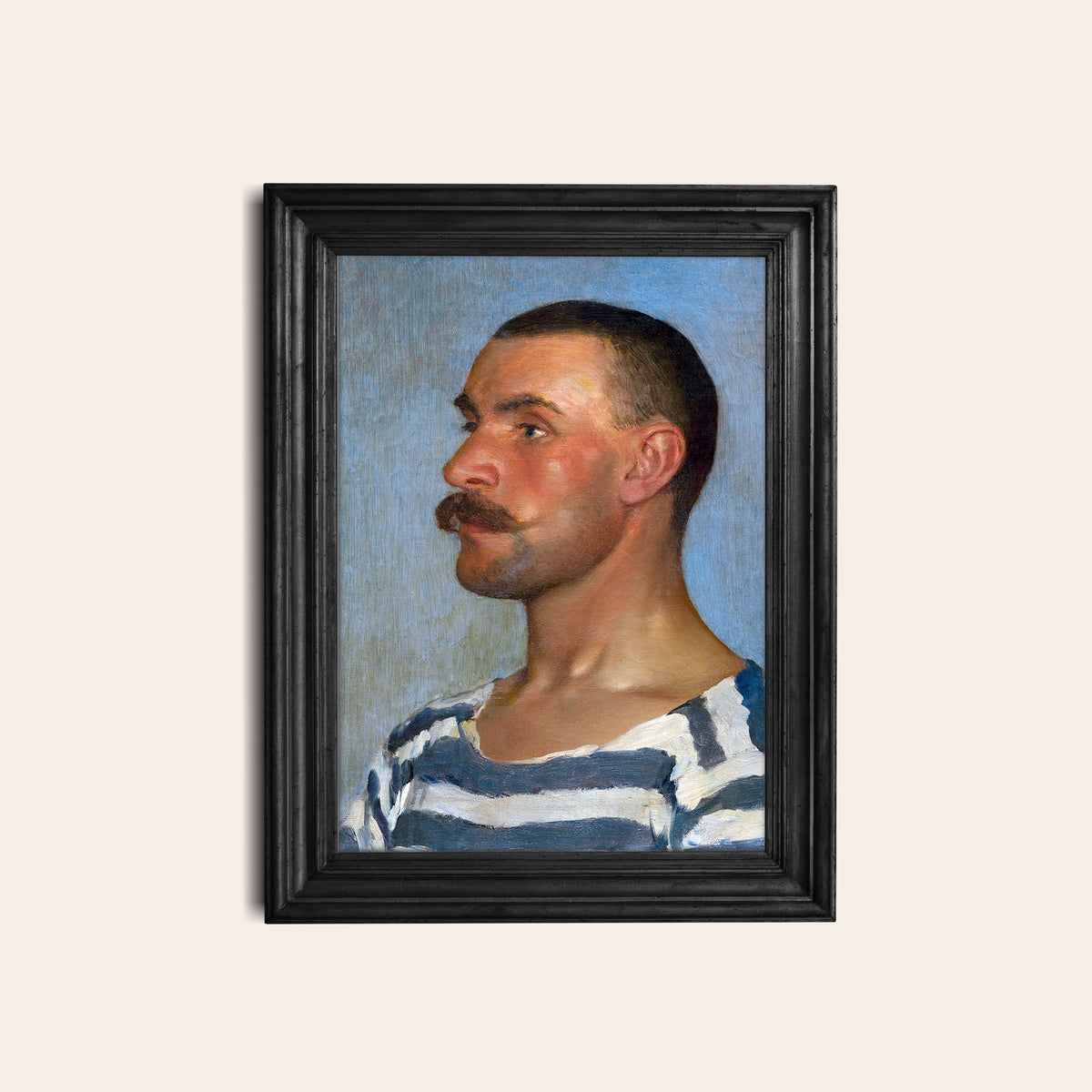 Framed portrait of a man with a mustache wearing a striped shirt hung on a light background
