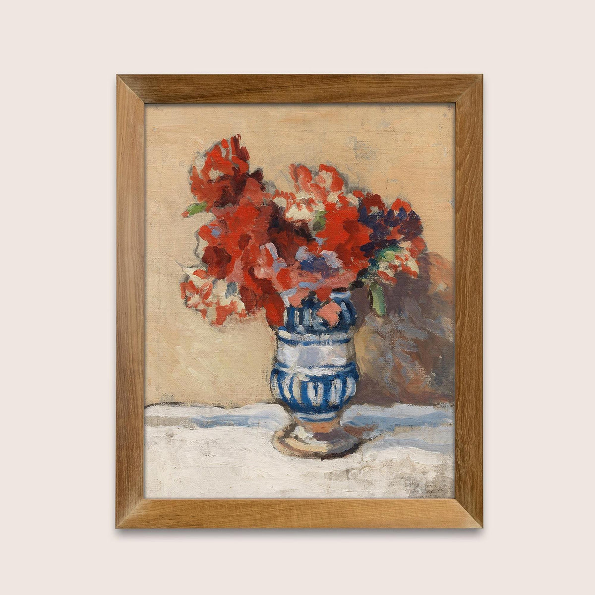 A fine art print of a still-life oil painting of red flowers in a blue and white striped vase. The print is displayed in a simple wooden picture frame.