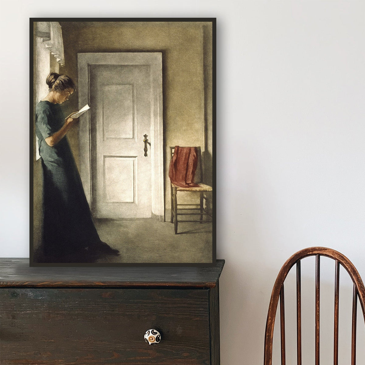 Wooden chair in front of a dark wooden dresser with a mirror on top