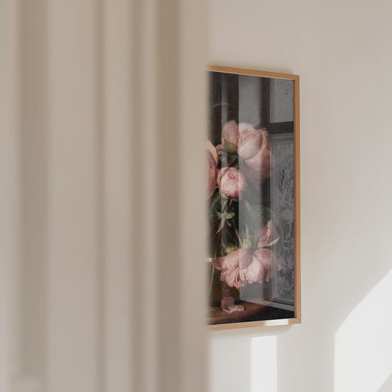 A video panning in from the left, over a framed artwork of pink peonies.