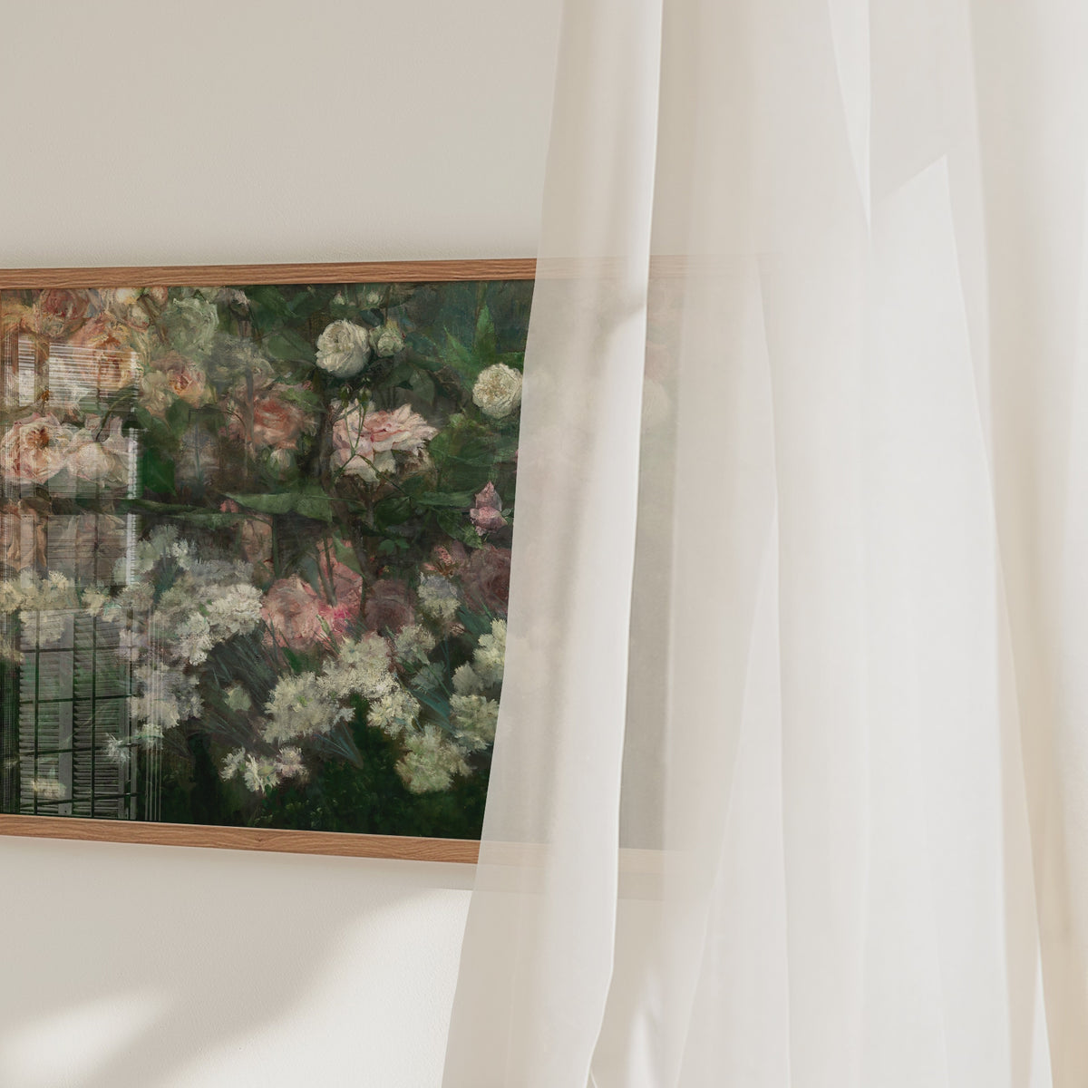 A video of a framed art print of a rose garden in full bloom. The video pans across and there is a net curtain wafting in the breeze in the foreground.