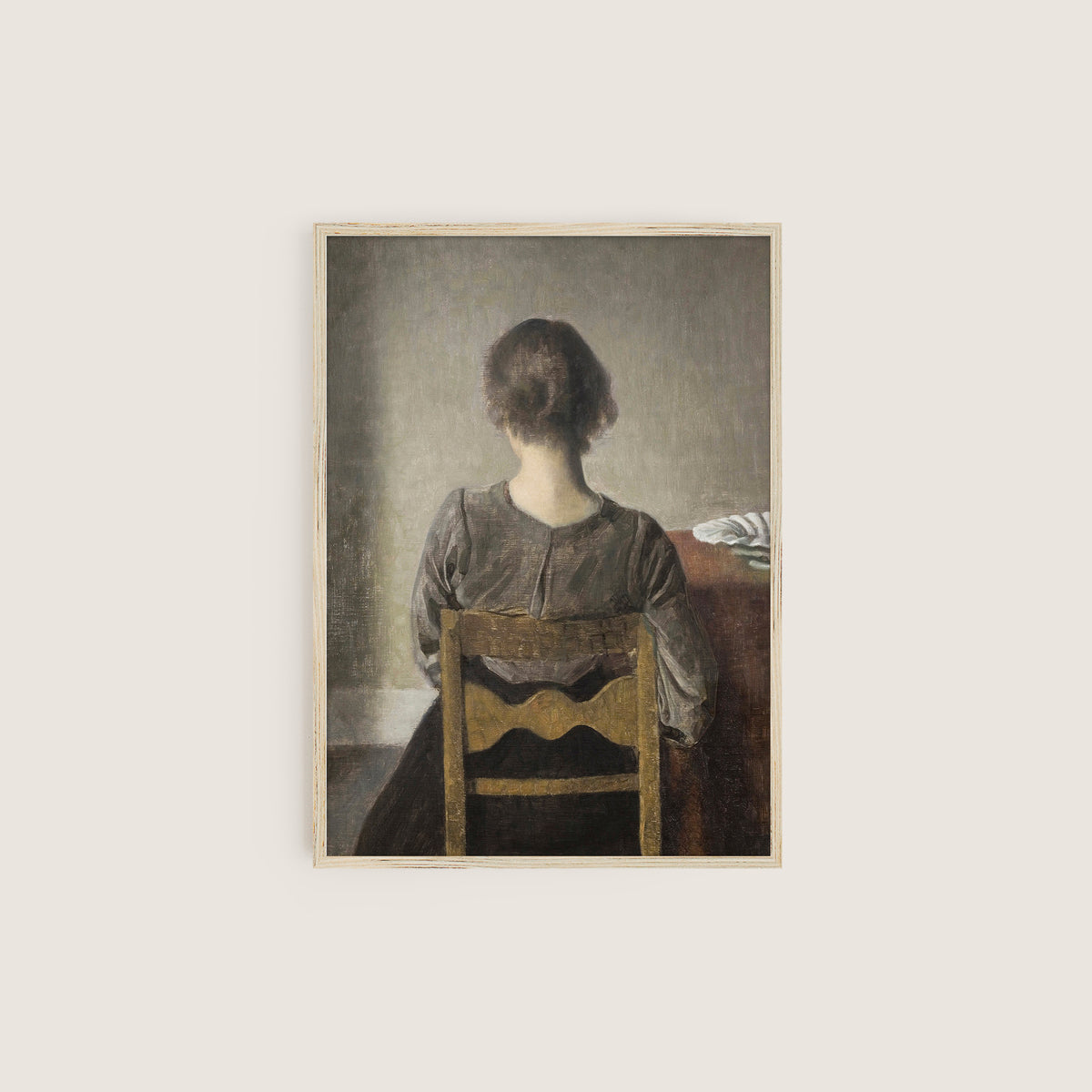 Framed artwork of a woman sitting on a chair with a neutral background