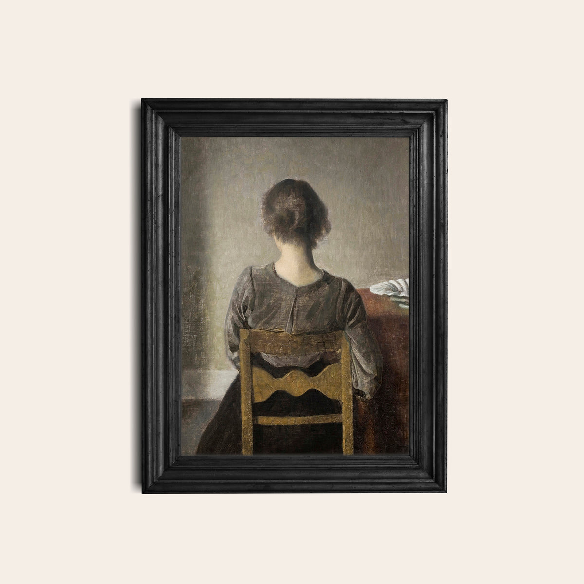 Framed print of a woman sitting on a chair with a neutral background