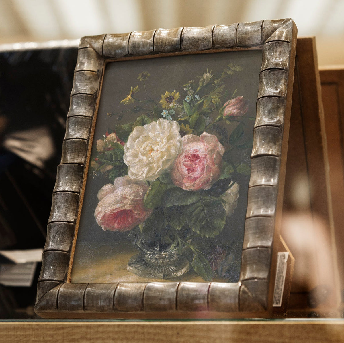 Floral print in a decorative frame on a wooden surface