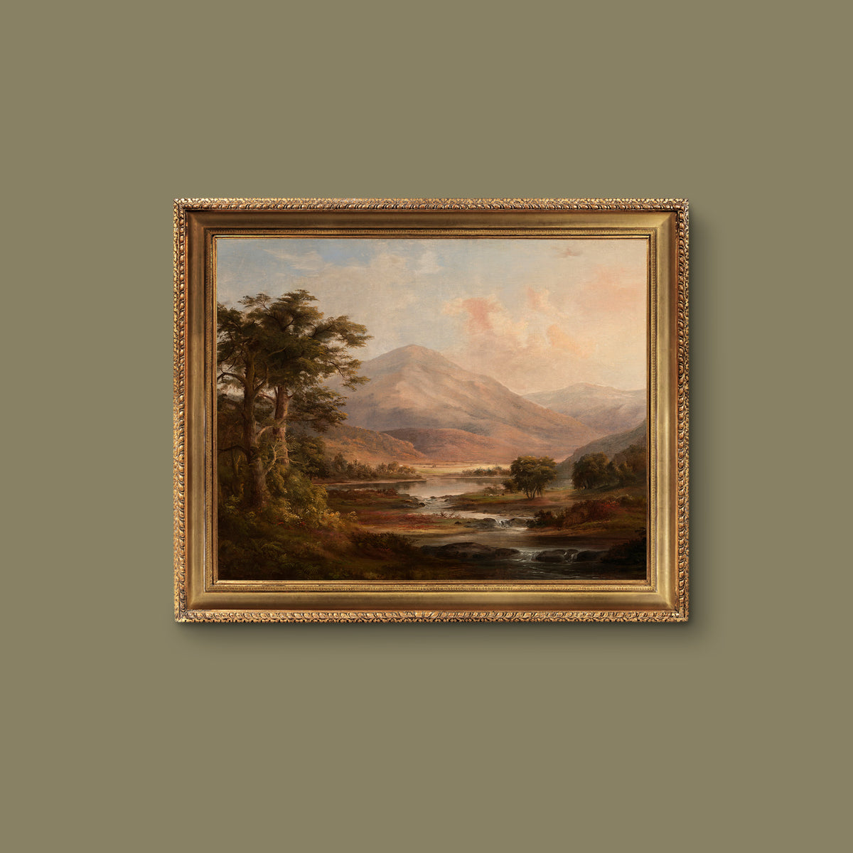 Framed landscape painting of a mountain scene with a gold frame on a green wall.