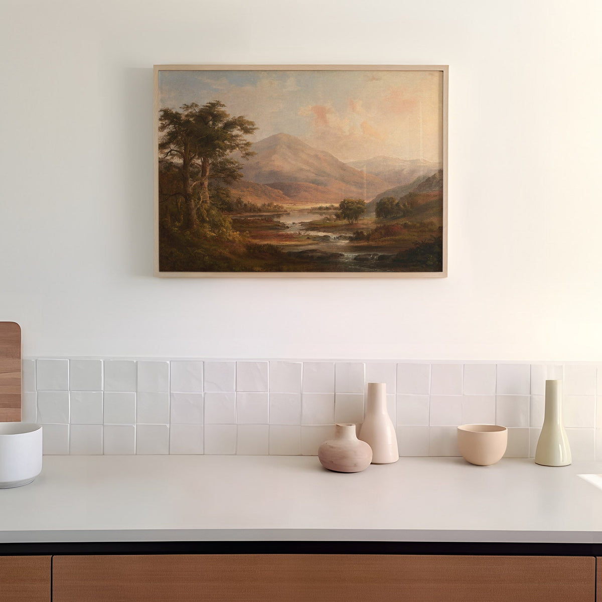 Kitchen with a painting of a Scottish landscape on the wall above a counter with decorative vases.