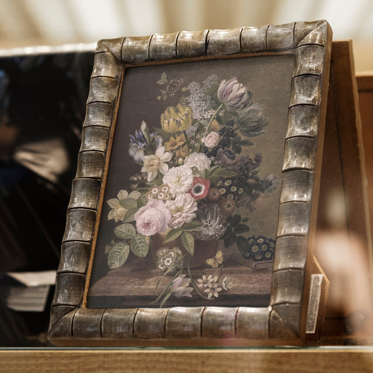 Decorative framed print of a floral still life on a wooden surface