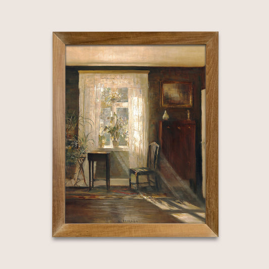 Framed print of an interior scene with a chair in a wooden frame on a white wall.